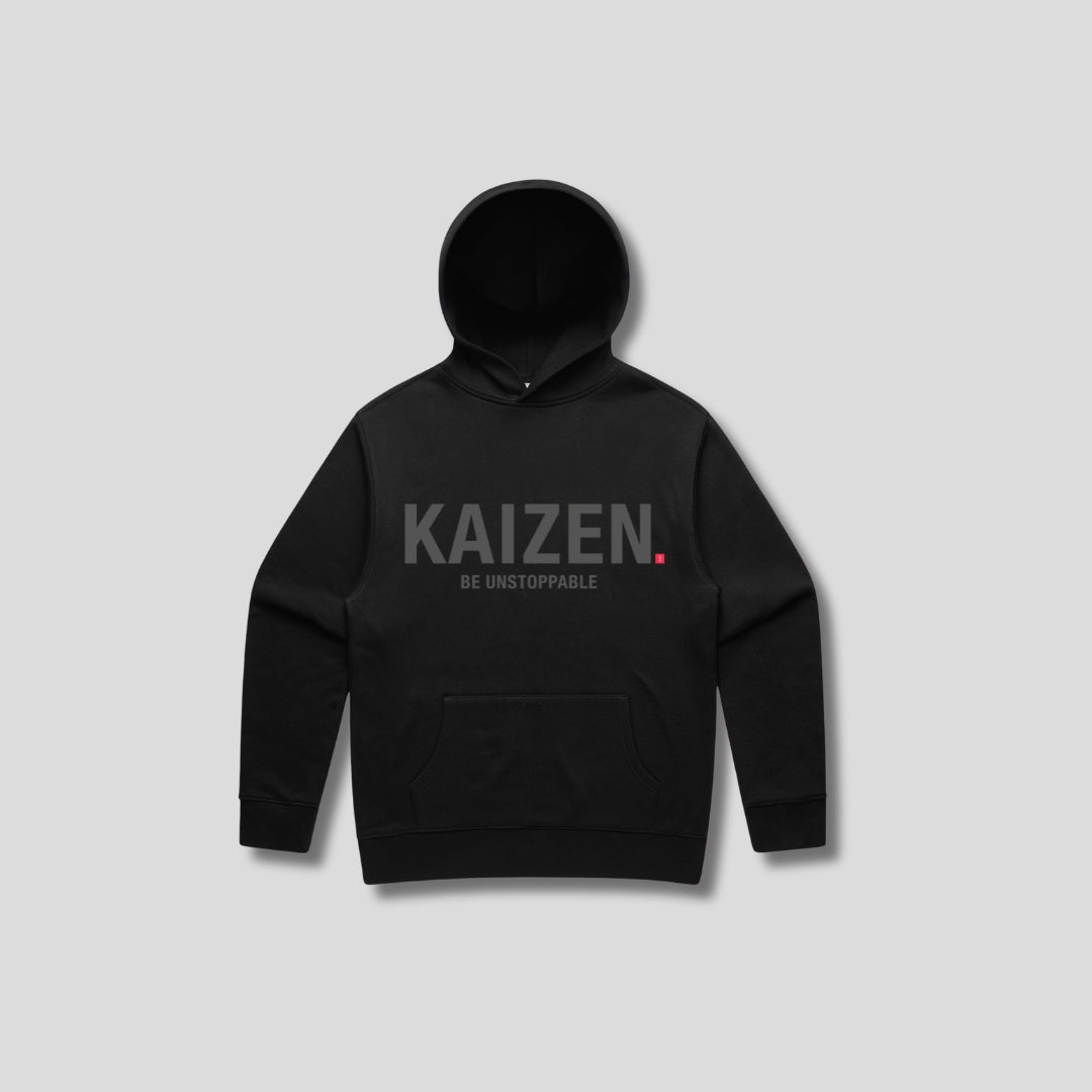 Black hoodie with 'KAIZEN' text, folded flat on grey background