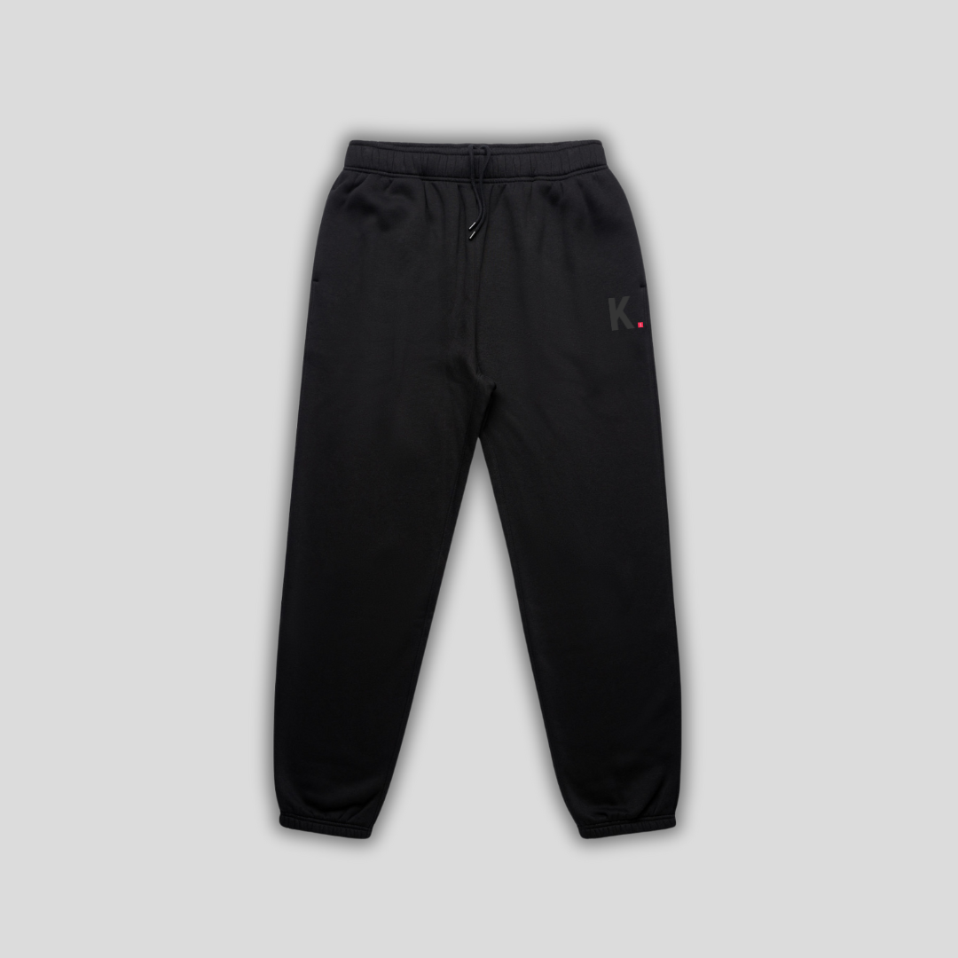 Black joggers with 'KAIZEN' logo, flat lay product image