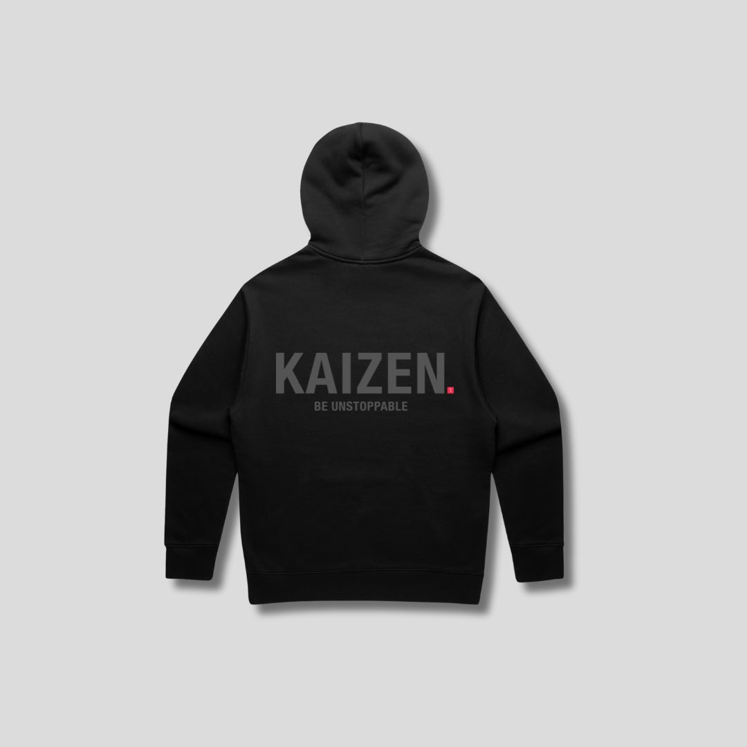 Black hoodie with 'KAIZEN' text, folded flat on grey background